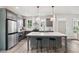 Open kitchen with stainless steel appliances, gray cabinets, and large island with stool seating at 907 E Green Ln, Clarkston, GA 30021