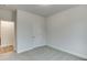 Neutral bedroom featuring gray carpet, white trim, a single door, and doorway to an adjacent room at 1250 Ainsworth Aly # 42, Sugar Hill, GA 30518