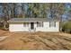 White ranch house with gray roof and black door, surrounded by trees at 3563 Bolfair Nw Dr, Atlanta, GA 30331