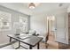 Home office featuring a desk, two chairs, two windows, and a modern light fixture at 3827 Cottage Cir, Tucker, GA 30021