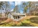 Home exterior featuring a back porch and a lush backyard with mature trees at 7018 Chimney Ridge Dr, Riverdale, GA 30296