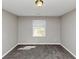 Cozy bedroom featuring plush carpet, neutral paint, and a bright window offering natural light at 7018 Chimney Ridge Dr, Riverdale, GA 30296