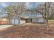 Inviting single-story home with a two-car garage and blooming tree accenting the facade at 7018 Chimney Ridge Dr, Riverdale, GA 30296