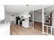Open concept kitchen offers white cabinets, stainless appliances, wood floors, and view to Gathering room at 7018 Chimney Ridge Dr, Riverdale, GA 30296