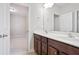 Bathroom with double sink vanity and a large mirror, with a door opening to a bedroom at 2471 Arnold Palmer Way, Duluth, GA 30096