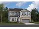 Two-story house with gray siding, brick accents, and a two-car garage at 319 Willam Gossett Dr, Canton, GA 30114