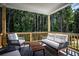 Relaxing screened-in porch featuring cushioned furniture and a view of the wooded backyard at 319 Willam Gossett Dr, Canton, GA 30114