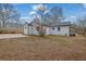 The backyard showcases the house's back exterior, surrounded by partially grassy and bare ground at 1900 Gober Se Ave, Smyrna, GA 30080