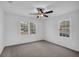 Bright bedroom featuring neutral carpet, ceiling fan, and two windows bringing in natural light at 1900 Gober Se Ave, Smyrna, GA 30080