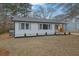 Beautifully renovated home featuring a modern design with black and white accents, fresh landscaping, and manicured lawn at 1900 Gober Se Ave, Smyrna, GA 30080