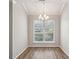 Bright and airy dining room with hardwood floors, a modern chandelier, and a large window at 6806 Glenridge Dr # E, Atlanta, GA 30328