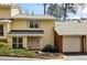 Charming townhouse featuring yellow siding, a brick facade and an attached single car garage at 6806 Glenridge Dr # E, Atlanta, GA 30328