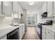 Bright kitchen with white cabinets, black appliances, and hardwood floors adjacent to the dining area at 6806 Glenridge Dr # E, Atlanta, GA 30328