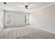 Carpeted main bedroom with neutral walls, ceiling fan, and large windows for ample light at 6806 Glenridge Dr # E, Atlanta, GA 30328
