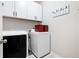 Bright laundry room with washer, dryer, and overhead cabinets at 121 Meridian Dr, Woodstock, GA 30188