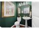 Elegant powder room with dark green walls, pedestal sink, and framed art at 121 Meridian Dr, Woodstock, GA 30188