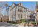 Three-story townhome with gray brick exterior, black fence, and manicured landscaping at 160 Cricket Ln, Alpharetta, GA 30009