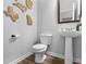 Small half-bath with neutral paint, hardwood floors, and a pedestal sink at 3 Derrick Ave, Hampton, GA 30228