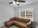 Spare bedroom is well-lit and features a leather couch and ceiling fan at 3 Derrick Ave, Hampton, GA 30228