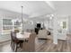 Open concept dining room with modern chandelier and hardwood flooring, flowing to living room at 3 Derrick Ave, Hampton, GA 30228