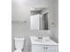 Well-lit bathroom with a single sink vanity, large mirror, and grey wall at 2222 Mcafee Rd, Decatur, GA 30032