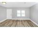 Bright bedroom with laminate wood floors, a window, and a white door at 2222 Mcafee Rd, Decatur, GA 30032