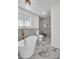 Luxurious bathroom with soaking tub, marble floors, and glass-enclosed shower at 2645 Shadow Woods Ne Cir, Marietta, GA 30062