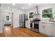 White kitchen with stainless steel appliances and hardwood floors at 1183 Cahaba Dr, Atlanta, GA 30311