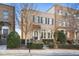 Brick front of a three-story townhome with shutters and a dark door at 3156 Neal Ct, Cumming, GA 30041