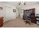 Carpeted bedroom with a ceiling fan, closet, and a built-in desk area perfect for a home office at 5659 Brookstone Nw Dr, Acworth, GA 30101