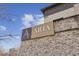 The Aria Village community sign against a brick wall under a blue sky at 6442 Canopy Dr, Sandy Springs, GA 30328