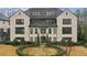 Luxurious exterior of a white brick townhome with manicured landscaping and black framed windows at 6442 Canopy Dr, Sandy Springs, GA 30328