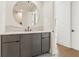 Modern bathroom with a round mirror and dark gray cabinets at 260 Guild Ln, Fayetteville, GA 30214