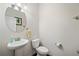 Cozy half-bathroom with a pedestal sink, toilet, and neutral wall color at 522 Spring View Dr, Woodstock, GA 30188