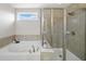 Bathroom with a soaking tub, separate glass shower, and tiled surround exudes relaxation and luxury at 522 Spring View Dr, Woodstock, GA 30188