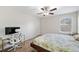 Comfortable bedroom with a ceiling fan, desk and a floral bedspread at 522 Spring View Dr, Woodstock, GA 30188