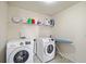 Functional laundry room equipped with modern washer, dryer, and storage shelf at 522 Spring View Dr, Woodstock, GA 30188