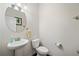 Clean powder room with pedestal sink and oval mirror at 522 Spring View Dr, Woodstock, GA 30188