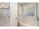 Bathroom with soaking tub and window, conveniently located near the bedroom at 1016 Madeline Ct, Loganville, GA 30052