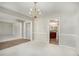 Dining room with chandelier, neutral walls, and view of kitchen at 1016 Madeline Ct, Loganville, GA 30052