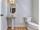 Simple powder room with pedestal sink and hardwood floor at 2790 Laurel Valley Trl, Buford, GA 30519