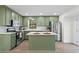 Modern kitchen with green cabinets, island, and stainless steel appliances at 607 Ann Ct, Woodstock, GA 30188