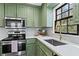 Modern kitchen with green cabinets and stainless steel appliances at 607 Ann Ct, Woodstock, GA 30188