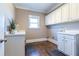 Bright laundry room with white cabinets and hardwood floors at 1150 Brushy Mountain Rd, Rockmart, GA 30153