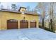 Three-car garage with concrete driveway and stucco exterior at 1605 Brandon Hall Dr, Atlanta, GA 30350