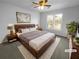 Virtually staged main bedroom with wood platform bed and large window at 2190 Wellington Cir, Lithonia, GA 30058