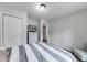 Bright bedroom with a closet, drawers, TV and gray and white bedding, creating a calming retreat at 2205 Castle Royale Dr, Lawrenceville, GA 30043