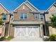 Brick front of townhome featuring a 2-car garage at 1216 Foxcroft Ln, Cumming, GA 30041