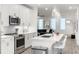 Modern kitchen featuring white cabinets, stainless steel appliances, and a center island with seating, flowing to the living area at 396 Pratt Se Dr # 1932, Atlanta, GA 30315