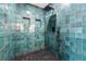 Spa-like shower with teal tile, rainfall shower head, and built-in shelves at 126 Marona Ne St, Atlanta, GA 30307